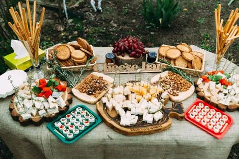 Laying of various cheeses on a large table in the open air. Stock Photos