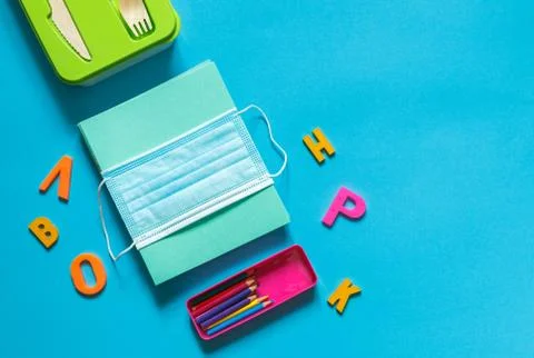 Layout on a blue background. A stack of notebooks, a pencil case with colored Stock Photos