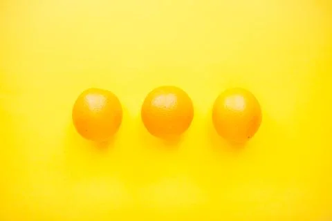 Layout of bright orange oranges on a bright yellow background. Stock Photos