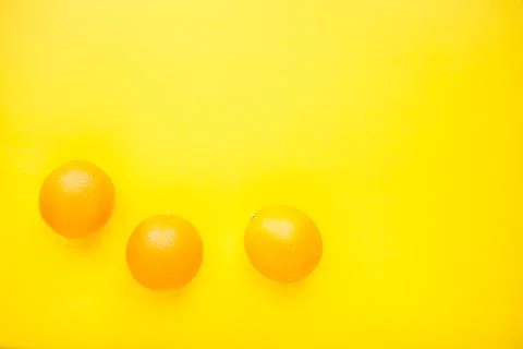 Layout of bright orange oranges on a bright yellow background. Stock Photos