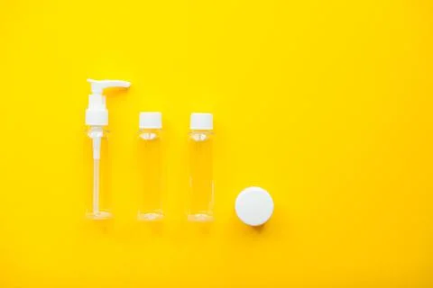 Layout on a bright yellow background. Jars for cosmetics. Travel set Stock Photos