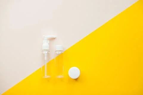 Layout on a bright yellow background. Jars for cosmetics. Travel set Stock Photos