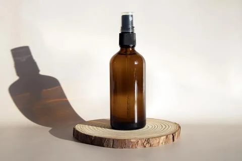 Layout of a brown glass bottle with an atomizer. The spray bottle stands on a Foto stock