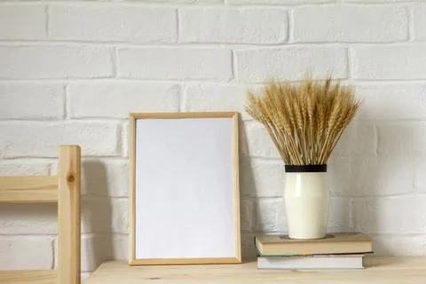 The layout of an empty photo frame on the table. A vase with dry grass. A min Stock Photos