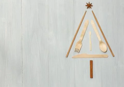 Layout in the form of a Christmas tree made of wooden Cutlery. On a light wooden Stock Photos