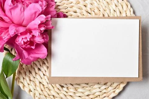 The layout is made of a kraft envelope and the color of a peony on a gray bac Stock Photos