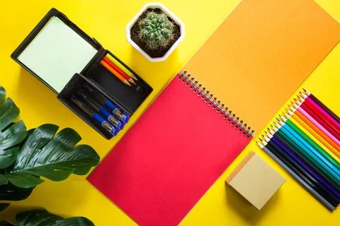 Layout of multi-colored stationery on a yellow background: spiral notebook, c Stockfoto's