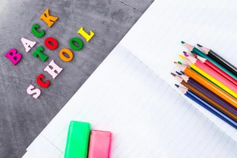 The layout of school supplies on a dark gray background. Top view, the sun's  Stock Photos