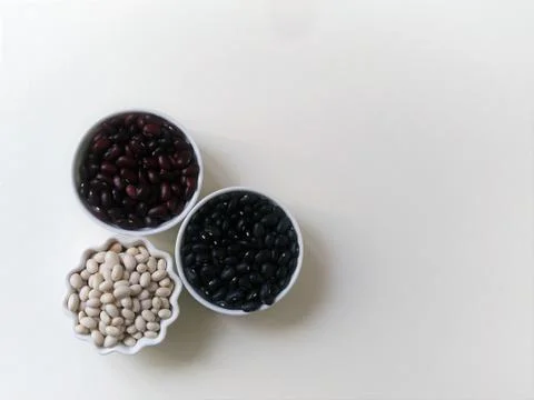 Layout three bowls of white, red and black beans on a white background. Top v Stock Photos
