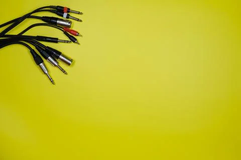 Layout of various audio cables on a yellow background.Copy space Stock Photos