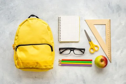 Layout of yellow school backpack full of stationery with apple Foto stock