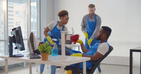 Lazy african janitor refusing to help team cleaning office Stock Footage 148229928