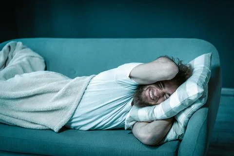 Lazy Guy Refuses to Get up Early in the Morning for Work. Man Lies on the Couch Stock Photos