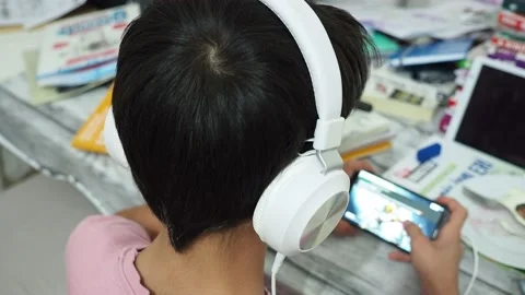 The lazy kid preparing for the exam is dealing with a cell phone, Stock Footage 140868238