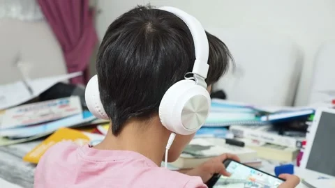 The lazy kid preparing for the exam is dealing with a cell phone, Vídeo Stock 140870032