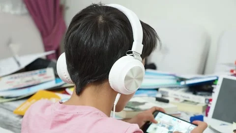 The lazy kid preparing for the exam is dealing with a cell phone, Stock Footage 140870078