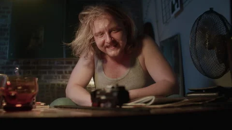 A lazy man sitting on a couch in his apartment and playing with a toy train Stock-Footage 259690382