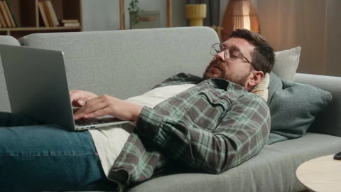 Lazy relaxing lying on sofa couch Caucasian man male freelancer businessman Stock Footage 292893516