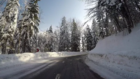 LD Car driving fast  up a snowy mountain road in sunshine Stock Footage 86344643