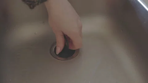 LD Female hand placing a plug into the kitchen sink and filling it with water Stock Footage 264945282