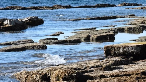 LD Waves gently splashing against the rocky beach in the Mediterranean Stock Footage 125692793