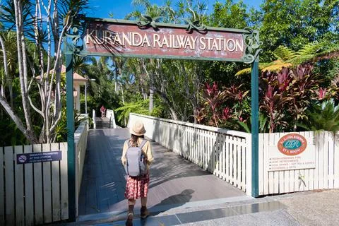 A lday is walking through the gate of Kuranda raiway station Stock Photos