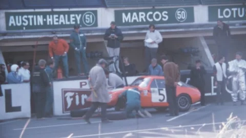 Le Mans - 1967: Austin-Healey Sprite Le Mans stops at the pit stop, team works Stock Footage 280177607