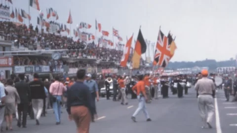 Le Mans - 1967: Crowd at the starting parade celebrates with international flags Stock Footage 280177464
