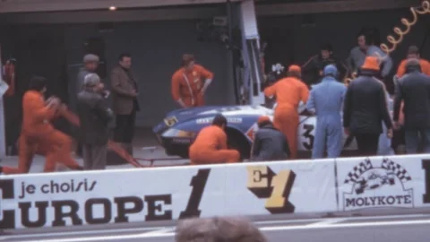 Le Mans - 1972: Pit crew works on a Ferrari, mechanics refuel and change tires Stock Footage 280177788