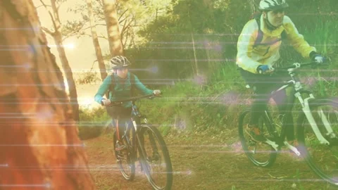 Lead and rear cyclists starting downhill avoiding roots for sport with light Stock Footage 333595159