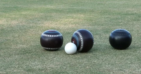 The lead ball is knocked away from the kitty during lawn bowls Video stock 124001475