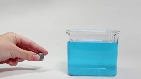 Lead Ball Sinking in Blue Liquid Experiment Video stock 308499101