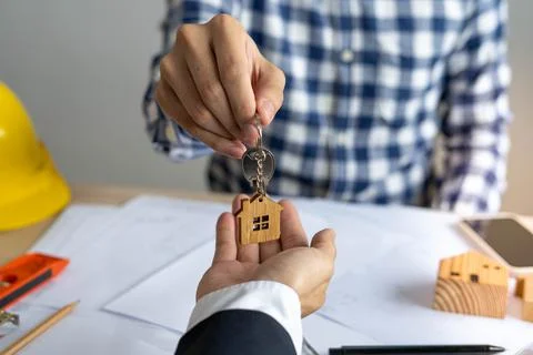 The lead contractor or engineer sends the house keys to the real estate broke Foto stock