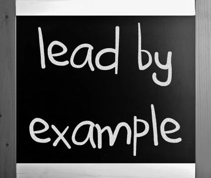"lead by example" handwritten with white chalk on a blackboard Stock Illustration