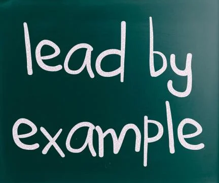 "lead by example" handwritten with white chalk on a blackboard Stock Illustration