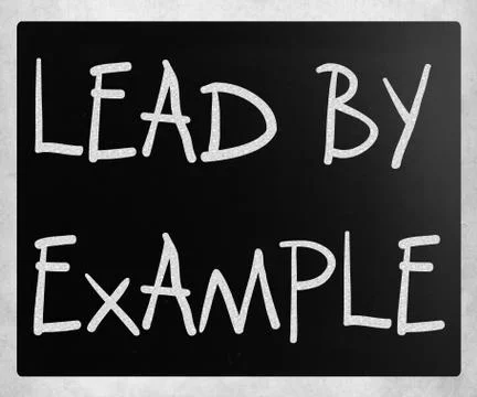 "Lead by example" handwritten with white chalk on a blackboard Stock-Fotos