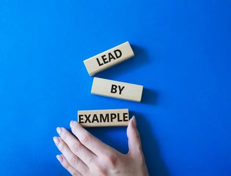 Lead by Example symbol. Concept word Lead by Example on wooden cubes. Busin.. Stock Photos