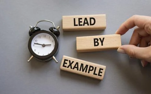 Lead by Example symbol. Concept word Lead by Example on wooden cubes. Busin.. Stock Photos