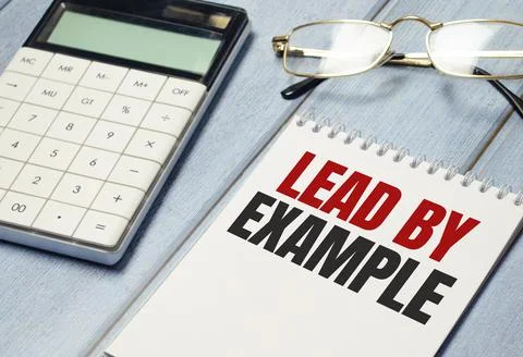 Lead by example text on notepad and glasses, calculator on wooden background Stock Photos