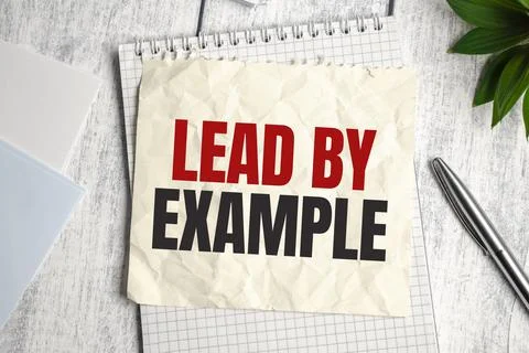 Lead by example, text on white paper on the light background with charts pape Stock Photos