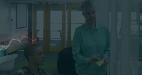 Lead facilitator selecting note and grouping notes on board while graph staying Stock Footage 330444090