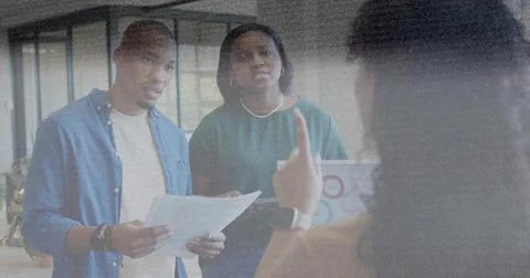 Lead gesturing, man reading papers, woman checking laptop charts, animated data Stock Photos