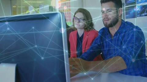 Lead operator moving mouse and typing, causing animated network overlay showing Stock Footage 334337994