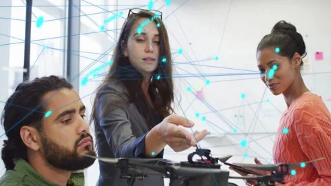Lead pointing at drone while engineer adjusting and PM tapping tablet causing Stock Footage 333192918
