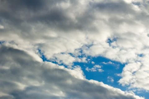 Lead rain clouds envelop the blue sky Stock Photos