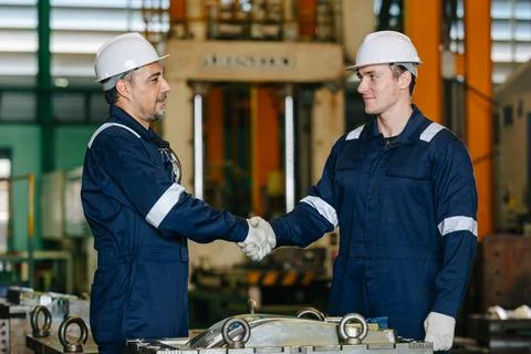 Lead senior engineer worker hand shaking with young man for deal success jo.. Stock Photos