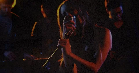 Lead singer performing on dark stage, wi... | Stock Video | Pond5
