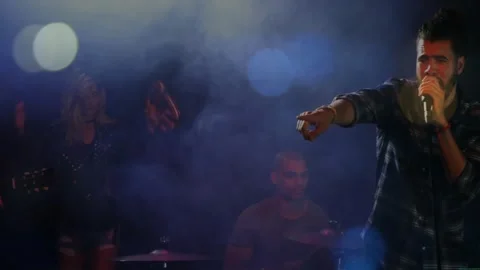 Lead singer stepping forward on music cue, pointing toward crowd and singing Stock Footage 331272431