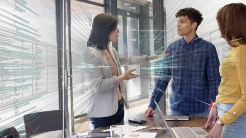 Lead starting discussion; team gesturing over laptop, docs, animated code Stock Footage 333277921