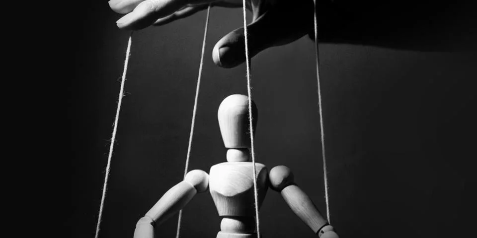 Leader hand controls the puppet concept of issuing orders and following them Stock Photos